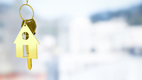 Animation-of-golden-house-keys-against-blurred-view-of-tall-buildings