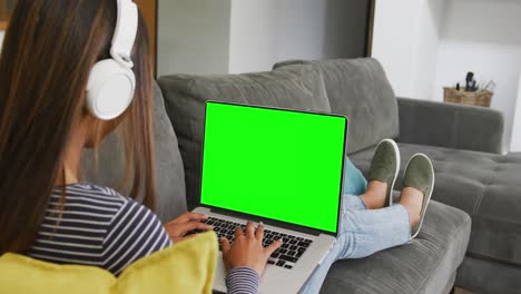 Biracial-female-student-with-headphones-using-laptop-with-copy-space-in-slow-motion