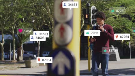 Animation-of-social-media-icons-over-african-american-man-using-smartphone-in-street