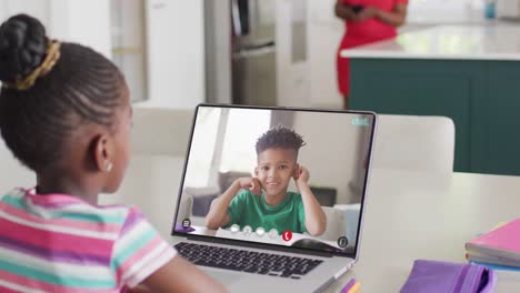 Vielfältiges-Schulmädchen-Führt-Laptop-Videoanruf-Mit-Gemischtrassigem-Schuljungen-In-Zeitlupe