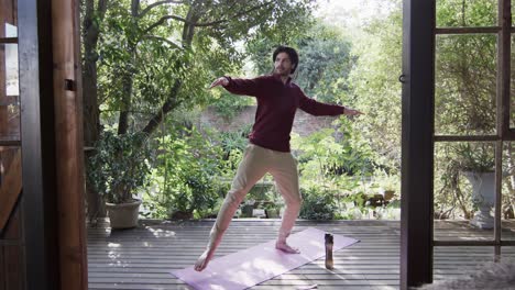 Caucasian-man-practicing-yoga-on-terrace-in-sunny-nature,-slow-motion