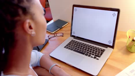 African-american-casual-businesswoman-using-laptop-with-copy-space-on-screen-in-office,-slow-motion