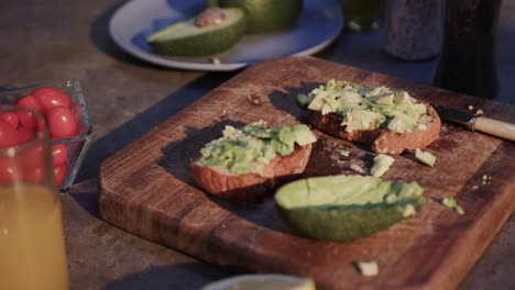 Close-up-of-avocado-toast,-vegetables-and-juice-in-kitchen,-slow-motion