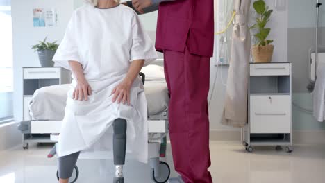 Mittelteil-Eines-Männlichen-Arztes,-Der-Im-Krankenhaus-Mit-Einer-Kaukasischen-Patientin-Mit-Beinprothese-Spricht