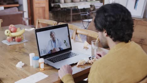 Caucasian-man-making-video-call-using-laptop-with-male-doctor-on-screen,-slow-motion