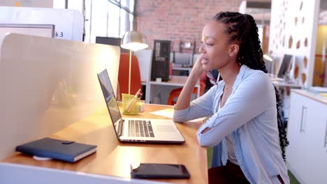 Happy-african-american-casual-businesswoman-having-laptop-video-call-in-office,-slow-motion