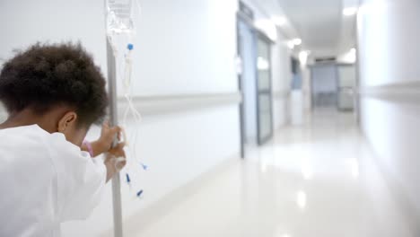 Afroamerikanisches-Mädchen-Mit-Tropf-Läuft-Im-Krankenhauskorridor,-Zeitlupe,-Kopierraum