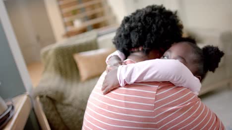 African-american-mother-and-daughter-hugging-at-home,-slow-motion