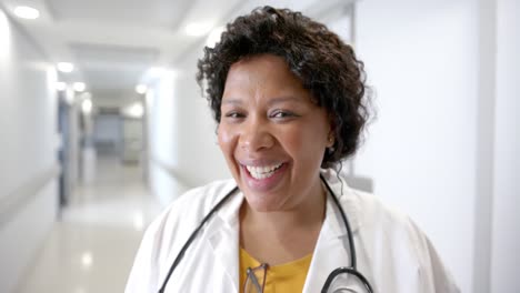 Porträt-Einer-Glücklichen-Afroamerikanischen-Ärztin-Im-Krankenhausflur,-Zeitlupe