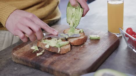 Hands-of-caucasian-man-preparing-avocado-toast-in-kitchen,-slow-motion