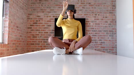 African-american-casual-businesswoman-using-vr-headset-sitting-on-table-in-meeting-room,-slow-motion