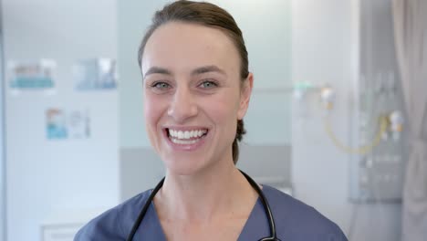Portrait-of-happy-caucasian-female-doctor-in-hospital-room,-slow-motion