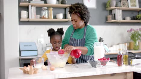 Glückliche-Afroamerikanische-Mutter-Und-Tochter-Bereiten-Teig-In-Einer-Schüssel-In-Der-Küche-Zu,-Zeitlupe