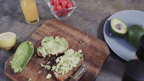 Close-up-of-avocado-toast,-vegetables-and-juice-in-kitchen,-slow-motion
