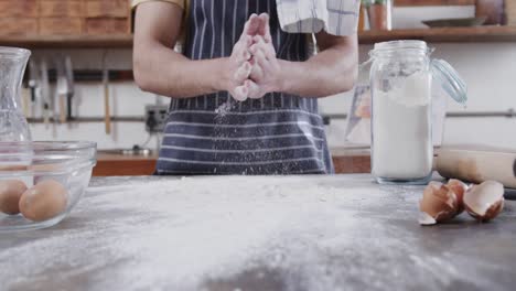 Midsection-of-caucasian-man-preparing-bread-dough-in-kitchen,-copy-space,-slow-motion