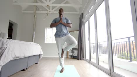 Afroamerikanischer-Mann,-Der-Zu-Hause-Yoga-Macht-Und-Meditiert,-Zeitlupe