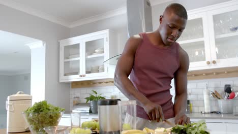 Hombre-Afroamericano-Preparando-Batido-Saludable-En-La-Cocina-De-Casa,-Cámara-Lenta
