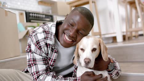 Portrait-of-happy-african-american-man-sitting-on-stairs-with-his-pet-dog-at-home,-slow-motion