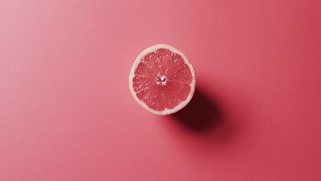 Video-of-sliced-red-grapefruit-with-copy-space-over-red-background