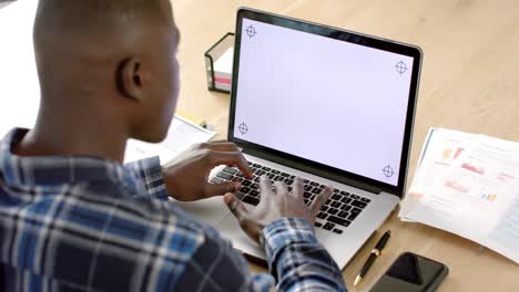 Afroamerikanischer-Mann-Sitzt-Am-Tisch-Und-Benutzt-Laptop-Mit-Kopierplatz-Auf-Dem-Bildschirm-Zu-Hause,-Zeitlupe