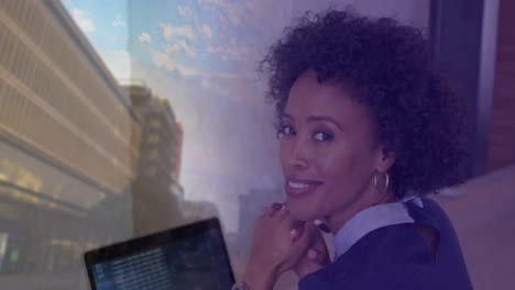 Animation-of-biracial-businesswoman-with-laptop-over-cityscape