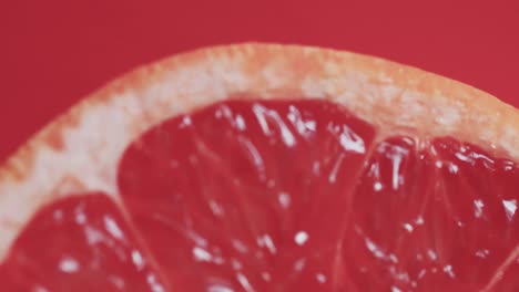 Video-Von-Geschnittener-Roter-Grapefruit-Mit-Kopierraum-Auf-Rotem-Hintergrund