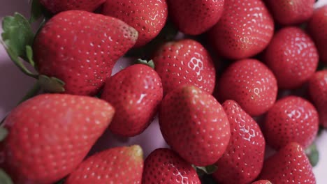 Video-of-close-up-of-strawberries-over-pink-background