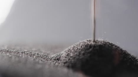 Video-of-close-up-of-hourglass-with-sand-pouring,-copy-space-on-black-background