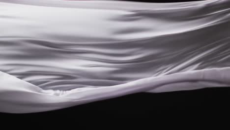 Animation-of-white-fabric-blowing-with-copy-space-over-black-background