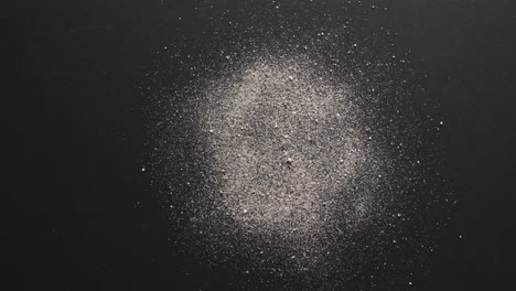 Video-of-close-up-of-sand-grains-and-copy-space-on-black-background