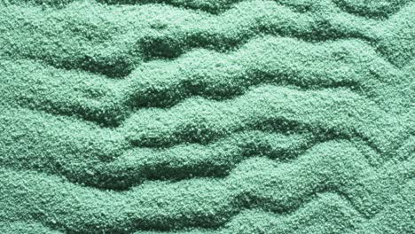 Video-of-close-up-of-green-coloured-sand-with-pattern-and-copy-space-background