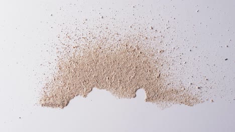 Video-of-close-up-of-sand-grains-and-copy-space-on-white-background