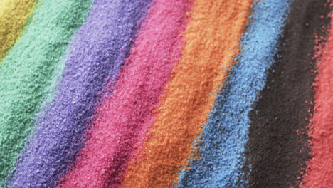 Video-of-close-up-of-multi-coloured-sand-grains-and-copy-space-background