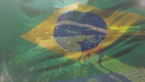 Animation-of-waving-brazil-flag-over-aerial-view-of-caucasian-couple-with-daughter-walking-in-garden