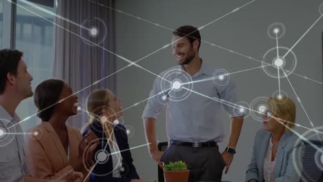 Animation-of-network-of-connections-over-diverse-colleagues-clapping-for-a-caucasian-man-at-office