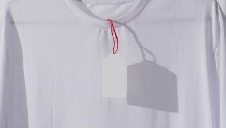 Video-Eines-Weißen-T-Shirts-Mit-Etikett-Und-Kopierraum-Auf-Weißem-Hintergrund