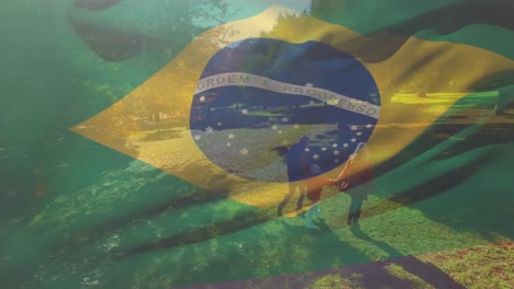Animation-of-waving-brazil-flag-over-aerial-view-of-caucasian-couple-with-daughter-walking-in-garden