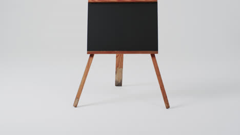 Video-of-blackboard-sign-on-wooden-stand-with-copy-space-on-white-background