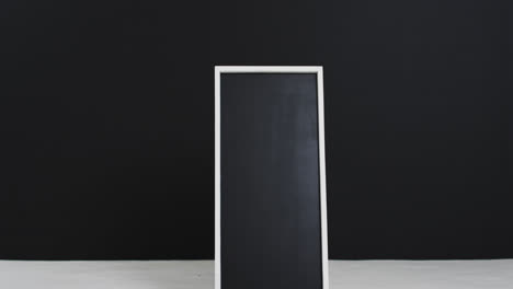 Video-Eines-Tafelschilds-Auf-Weißem-Ständer-Mit-Kopierraum-Auf-Schwarzem-Hintergrund