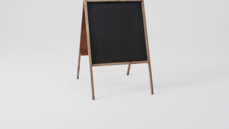 Video-of-blackboard-sign-on-wooden-stand-with-copy-space-on-white-background