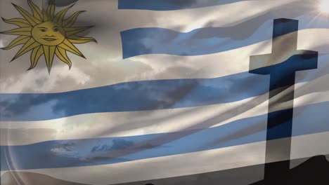 Animation-of-waving-uruguay-flag-against-silhouette-of-a-cross-against-clouds-in-the-sky