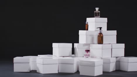Video-of-beauty-products-with-white-cardboard-boxes-with-copy-space-over-black-background