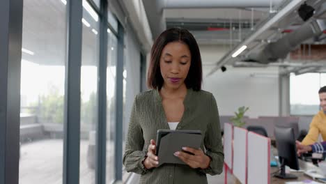 Afroamerikanische-Geschäftsfrau-Nutzt-Digitales-Tablet,-Während-Sie-Im-Büro-Geht