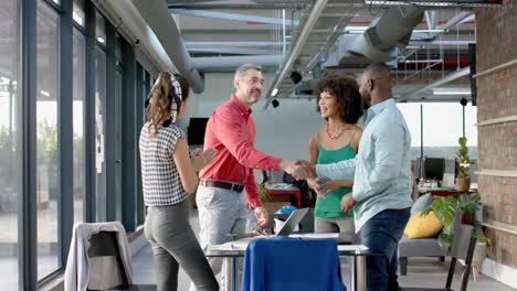 Team-of-diverse-colleagues-shaking-hands-with-each-other-at-office