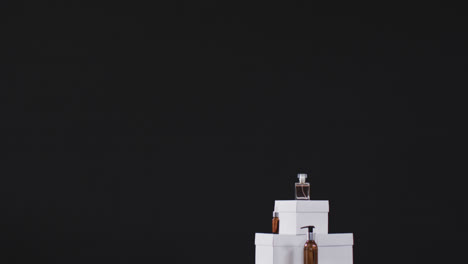 Video-of-beauty-products-with-white-cardboard-boxes-with-copy-space-over-black-background
