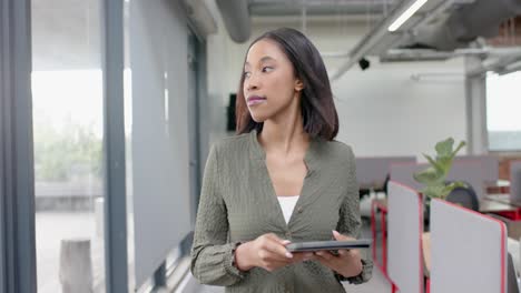 Afroamerikanische-Geschäftsfrau-Nutzt-Digitales-Tablet,-Während-Sie-Im-Büro-Geht
