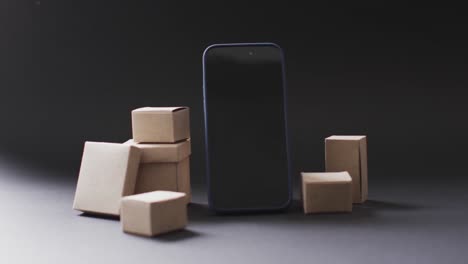 Video-of-smartphone-with-blank-screen-and-boxes-with-copy-space-on-black-background