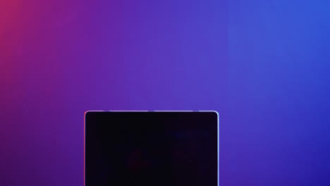 Video-of-laptop-with-blank-screen,-copy-space-on-neon-background