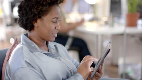 Happy-african-american-casual-businesswoman-using-tablet-in-office,-slow-motion