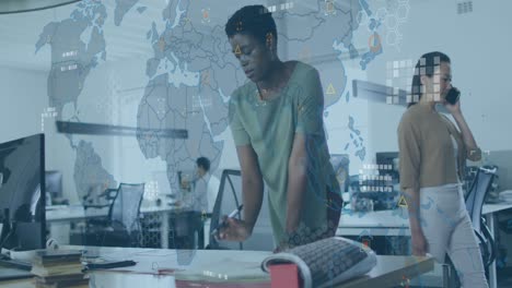 Animation-of-circuit-board-pattern-on-map-over-african-american-woman-analyzing-report-on-desk